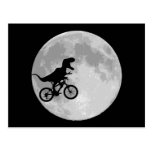 Dinossauro em uma bicicleta no céu com lua cartao postal