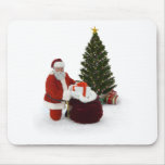 Papai noel que ajusta presentes pela árvore mousepads