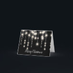 A corda elegante ilumina o cartão de Natal<br><div class="desc">As luzes brancas elegantes da corda ajustaram-se em um cartão de Natal preto do fundo.</div>