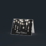 A corda elegante ilumina o cartão de Natal<br><div class="desc">As luzes brancas elegantes da corda ajustaram-se em um cartão de Natal preto do fundo.</div>