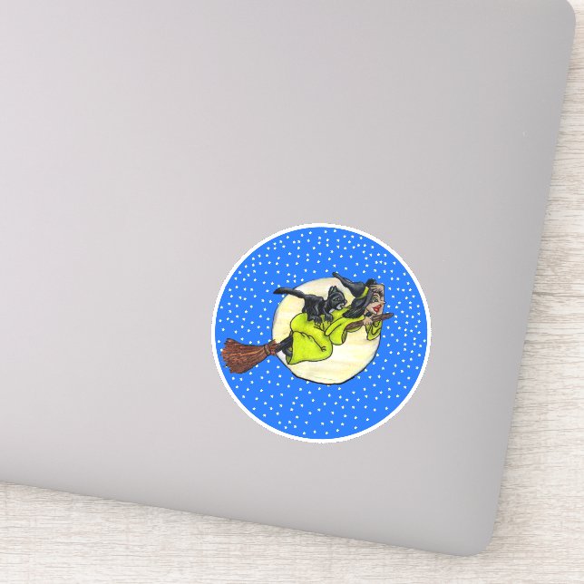 Adesivo Bruxa Segurando Chapéu Voando na Lua Passada em Ga (Detalhe)