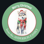 Adesivo Cachorro Siberiano Husky em Red Christmas Scarf an<br><div class="desc">Uma imagem de um adorável cão Siberiano Husky vestindo um lenço vermelho de inverno e que está no centro deste adesivo de Natal. A imagem é emoldurada numa borda verde circular que contém o texto personalizado em branco. Bonito para cartões de Natal,  correspondência e pacotes de presentes.</div>