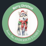 Adesivo Cachorro Siberiano Husky em Red Christmas Scarf an<br><div class="desc">Uma imagem de um adorável cão Siberiano Husky vestindo um lenço vermelho de inverno e que está no centro deste adesivo de Natal. A imagem é emoldurada numa borda verde circular que contém o texto personalizado em branco. Bonito para cartões de Natal,  correspondência e pacotes de presentes.</div>