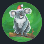 Adesivo Koala Bear Christmas<br><div class="desc">Os mantimentos de Natal Festivos do Urso Koala apresentam nosso fofinho Urso Koala vestindo um chapéu de Papai Noel. Muitos de nossos divertidos produtos de férias também mostram nossa fofa Koala de trás com — surpresa! - bebê Koala vestindo uma coroa sagrada. Muitos designs também apresentam um verde de Natal...</div>
