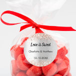 Adesivo Nomes de ouro rosa de prata de casamento Amor é do<br><div class="desc">Um fundo de olhar mal prateado. Personalize e adicione seus nomes e a data do casamento. Texto: O amor é doce. Decorado com rosa dourado confetti. Para favores doces como chocolate,  biscoitos.</div>