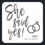 Adesivo Quadrado Ela Disse Que Sim! | Letra Festa de noivado Script<br><div class="desc">Um autocolante divertido e único, com letra de script, adaptado especificamente ao seu janto ou festa futuro de noivado. Ela mostra as palavras "Ela disse sim!" com anéis de casamento ao lado. Por baixo disto e por cima estão os nomes da noiva e do noivo e a data do noivado...</div>