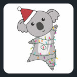 Adesivo Quadrado Koala Christmas Fairy Lights Cuja Boca É<br><div class="desc">O coala está vestindo um chapéu de Natal e está embrulhado em luzes de fadas. Os coalas são animais bonitos para o Natal como presentes para crianças.</div>