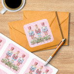 Adesivo Quadrado Pink Christmas Nutcracker Trio Square Sticker<br><div class="desc">Utilize esses adesivos quadrados coloridos em envelopes,  favoritos para festas,  presentes e muito mais! Um fundo cor-de-rosa glorioso contém um trio de malucos que estão em pé em evergreens de Natal. Dois tamanhos diferentes para escolher.</div>