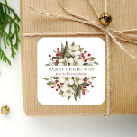Adesivo Quadrado Watercolor Felry Christmas Floral Magnolia Berries<br><div class="desc">Este adesivo personalizado apresenta um buquê de aquarela de flores brancas de magnólia,  verde e bagas vermelhas. No meio,  as palavras "Feliz Natal" aparecem na letra verde-oliva,  em fundo branco. Personalize o design com seu nome de família em itálico vermelho escuro.</div>
