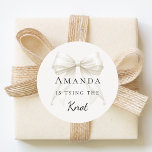 Adesivo Tying the knot ivory bow pearls Bridal Shower<br><div class="desc">Elevate your celebration with these chic bridal shower stickers. The design showcases a high-fidelity ivory,  cream colored bow intertwined with delicate pearl strands for a luxury finish. These labels are perfect for sealing bachelorette party invitation envelopes or adding to guest favor bags.</div>