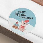 Adesivo Vegan Christmas com belos leitões e presentes<br><div class="desc">Este adesivo de Natal Vegan apresenta um belo leitão de desenho animado com um chapéu vermelho e cachecol e alguns presentes coloridos, sobre um fundo de neve. O texto negro diz "Natal Vegan da Feliz". Se precisar de ajuda, personalização adicional ou outros itens correspondentes, por favor, sinta-se à vontade para...</div>