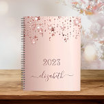 Agenda Ares rosa de lâmina douradas com monograma de gote<br><div class="desc">Um fundo metálico rosa-azul esfarelado, dourado, com elegante brilho rosa-dourado e estrelas brilhando, pingando. Personalize e adicione um ano 2023 (ou qualquer ano) e um nome. O nome é escrito em ouro rosa escuro com um grande roteiro de estilo, escrito à mão, com baloiços. Para manter as hastes, exclua apenas...</div>