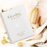 Agenda Dourado Script Future Sra. Wedding Planner<br><div class="desc">O design romântico apresenta uma flor floral macia em branco, "Future Mrs", e as palavras "Wedding Plan" numa escrita de tipografia de ouro contra fundo branco. Personalize facilmente seus nomes e data de escolha. A ideia perfeita de presente para a futura noiva organizar todas as suas necessidades de planeamento de...</div>