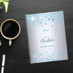 Agenda Monograma 2025 com brilho azul de prata<br><div class="desc">Um fundo metálico de aspecto fino prateado decorado com poeira azul esmaecida. Personalize e adicione seu primeiro nome,  iniciais do monograma,  nome do cheio e um ano.</div>