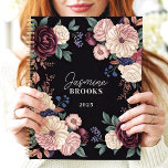 Agenda Nome Personalizado Floral Escuro Sofisticado<br><div class="desc">Este elegante design apresenta um arranjo luxuoso de flores em tons ricos de ameixa, creme, esbranquiçado e marinho, colocados contra um fundo preto dramático. O nome personalizado e o ano adicionam um toque refinado e único, perfeito para profissionais, estudantes ou qualquer pessoa que ame arte floral clássica e eterno. Ideal...</div>