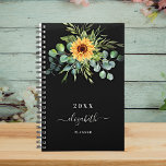 Agenda Nome preto de girassol eucalipto verde 2023<br><div class="desc">Um fundo negro. Decorado com girassóis,  eucalipto verde. Adicione um nome,  texto. O nome é escrito com um moderno estilo escrito à mão com traços. Para manter as hastes,  exclua apenas o nome da amostra,  deixe os espaços ou emoji na frente e depois do nome.</div>