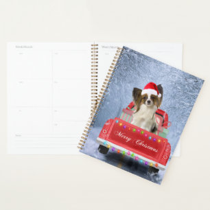 Agenda Papillon Dog em Neve sentado no Caminhão de Natal