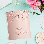 Agenda Rosa dourado com nome de monograma giratório 2025<br><div class="desc">Um fundo metálico rosa dourado falso, com brilho elegante rosa dourado e estrelas brilhantes caindo, pingando. Personalize e adicione um ano 2025 e um nome. O nome é escrito em ouro rosa escuro com um grande roteiro de estilo, escrito à mão, com baloiços. Para manter as hastes, exclua apenas o...</div>