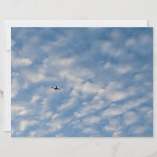 Airplane Crossing a Cloud-Filled Blue Sky