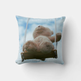 Almofada Beertje op schommel met bewolkte blauwe lucht.