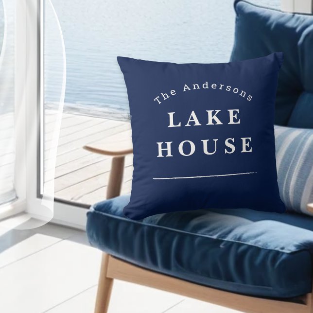 Almofada Casa de Lago Personalizada Azul Marinho Nome da Fa (A stylish navy blue throw pillow with "Lake House" text and custom name)