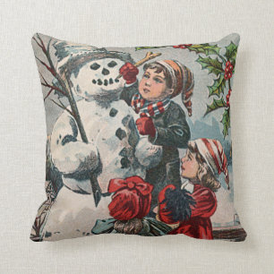 Almofada Crianças Fazendo Boneco de Neve com Azevinho