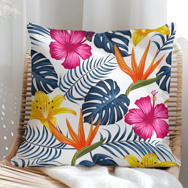 Almofada Design tropical colorido num travesseiro branco (Colorful tropical design on a white pillow in a sunny rattan armchair.)