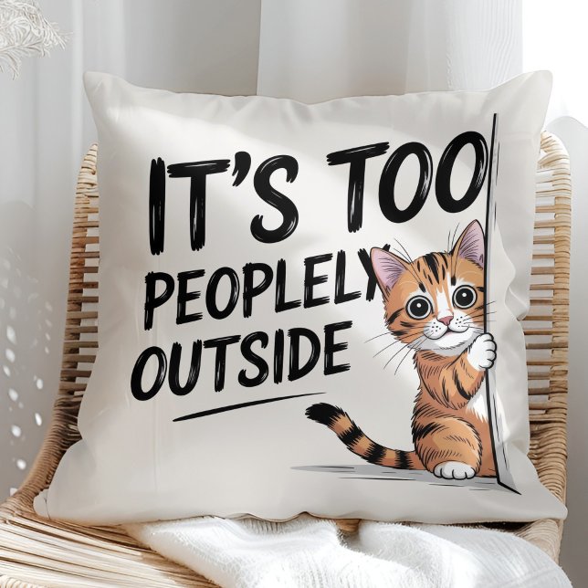 Almofada "É Muito Cheio Lá Fora" Gato Introvertido Divertid ("It's Too Peopely Outside" Funny Introvert Cat Throw Pillow in a sunny boho rattan chair.)