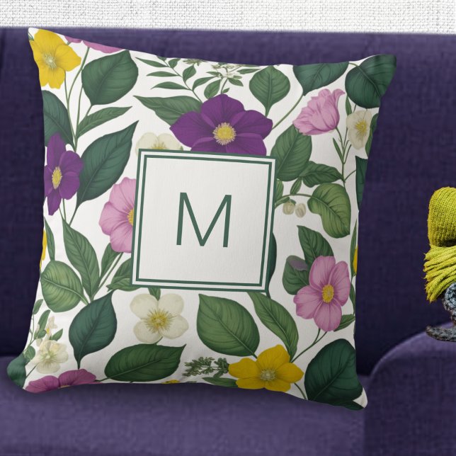 Almofada Flores De Impressão Floral Belas E Legantes (A pretty monogrammed cushion with purple, pink, yellow and white flowers and green leaves)