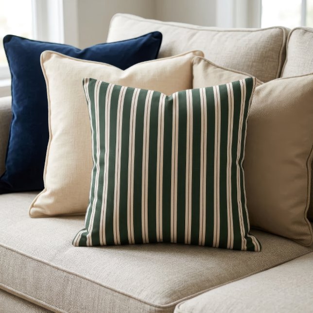Almofada Listras Retrô - Verde Escuro, Bege e Vermelho Escu (A pillow with a retro inspired stripe pattern sits on a couch in front of several other pillows.)