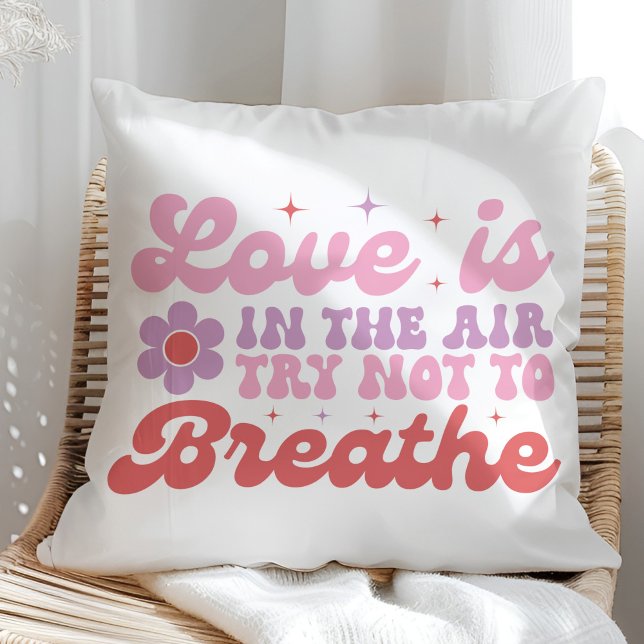Almofada O amor está no ar Engraçado Anti Valentine (Love is in the Air Funny Anti Valentine Throw Pillow on a sunny rattan chair.)
