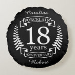 Almofada Redonda Aniversário de casamento tradicional da porcelana,<br><div class="desc">Uma design para celebrar 18 anos de casamento. Este design tem um design branco (Porcelana) de louros colorido sobre fundo preto. Porcelana é o presente tradicional para esta ocasião. No texto se lê Porcelana 18 anos de aniversário. Uma design romântica para comemorar seu 18º ano de casamento. Se você quiser...</div>