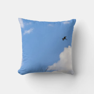 Almofada Solitary Bird Soaring Through Bright Blue Sky with