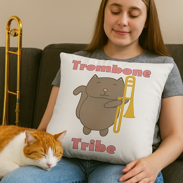 Almofada Tribu do Trombone Gato Marrom Fofo Letras Rosa (A throw pillow features a cute cat holding a trombone and the text trombone tribe in pink letters.)