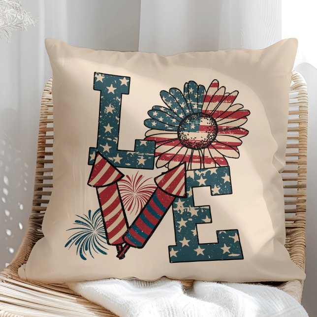 "AMOR" Almofada de Lançamento do Dia da Independên ("LOVE" American Flag Independence Day Throw Pillow in a sunny rattan armchair.)