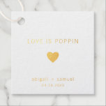 Amor É Casamento Moderno De Folha De Ouro<br><div class="desc">Moderno e elegante bonecas de casamento com um design mínimo com a mensagem "Love Is Poppin" com um coração, seus nomes e data abaixo. Todos os design estão em folha de ouro real sobre fundo branco. Estas simples etiquetas contemporâneas são perfeitas para o casal minimalista e acrescentam um toque pessoal...</div>
