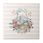 Azulejo De Cerâmica Coelhinho bonito em uma cesta com ovos e flores Bo<br><div class="desc">Um azulejo cerâmico com um pessegueiro e um padrão listrado branco. Uma ilustração digital feita com aquarelas. Um coelho encantador vestindo um vestido azul sentado em uma cesta cercada por seus ovos. Borboletas à volta da cesta que é decorada com um buquê de flores de rico.</div>