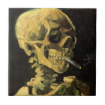 Azulejo De Cerâmica Crânio com cigarro queimado por Vincent van Gogh<br><div class="desc">Crânio com Cigarro queimado por Vincent van Gogh é um apos impressionismo de arte de vintage que ainda pinta a vida. Um retrato do esqueleto humano fumando. Imagem do excelente a utilizar em produtos anti-tabagismo. Fumar matares 1.000 a cada ano, ajudar alguém a parar de fumar hoje. Imagem de excelente...</div>