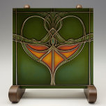 Azulejo De Cerâmica Emerald Grace Art Nouveau<br><div class="desc">Infusamos sua casa com a elegância eterno do "Azulejo cerâmico Emerald Grace Art Nouveau", uma peça impressionante que incorpora a fluidez e a beleza orgânica do movimento Art Nouveau. Esse azulejo cerâmico, impresso por Zazzle, apresenta um design captivador com linhas fluidas e um motivo central em tons ricos de laranja...</div>