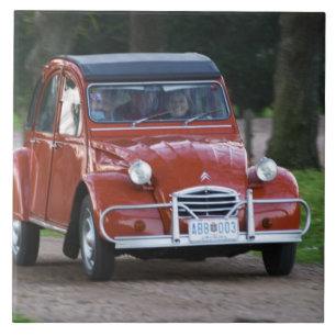 Azulejo De Cerâmica Um velho Citroen 2CV vermelho com uma mulher sorri