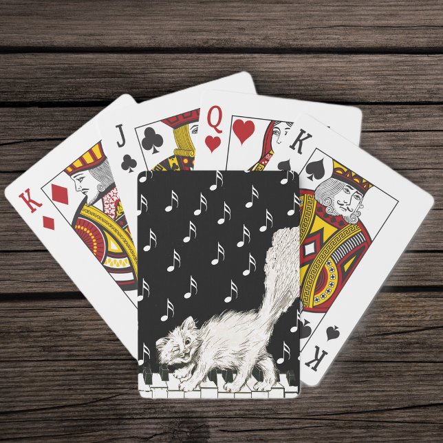 Baralho Gato Branco Fofo Sorridente e Piscando de Olho na  (Cute white winking cat fluffy tail walking on piano keys white music notes on black  playing cards.)