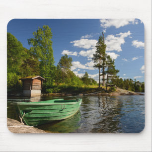 Barco verde em um fiorde no mousepad de Noruega