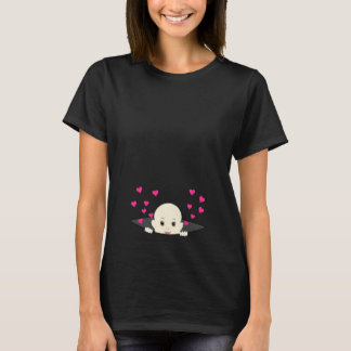 Bebê que espreita com a camisa da maternidade dos