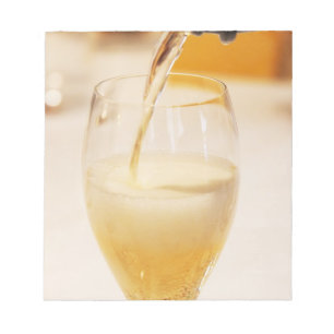 Bloco De Notas Uma taça de flûte sendo enchida com Gosset