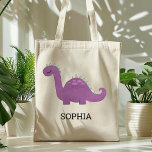 Bolsa Tote Bag Tote Personalizada do Dinossauro Púrpura<br><div class="desc">Esta bolsa de tote das meninas apresenta uma ilustração fofa de um dinossauro roxo e verde com manchas cor-de-rosa e pestanas longas. Personalize com o nome do seu filho em letras negras. Faz uma bolsa de excelente!</div>