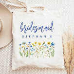 Bolsa Tote Bridesmaid de Script Azul Personalizado de Flores<br><div class="desc">Este simples e elegante saco de totes apresenta uma borda de flores silvestres em tons de amarelo e azul com caules verdes. A palavra "bridesmaid" aparece no script de escrita manual azul. Personalize-o com seu nome na fonte sans serif. Faz um presente perfeito para dama de honra!</div>