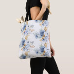 Bolsa Tote Casamento Floral em Branco Dourado e Azul Empoeira<br><div class="desc">Carregue seus pertences com estilo nesta linda bolsa adornada com um design floral macio e romântico em azul poeirado,  branco e dourado. Perfeita como lembrança de casamento,  bolsa diária elegante ou presente atencioso,  ela adiciona um toque de elegância floral a qualquer ocasião.</div>