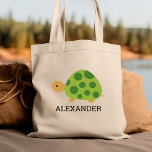 Bolsa Tote Cuja tartaruga verde é personalizada<br><div class="desc">Esta bolsa de tote para amantes de os animais mostra uma ilustração fofa de uma tartaruga verde. Personalize com o nome do seu filho em letras negras. Faz uma bolsa de excelente para rapazes ou raparigas!</div>