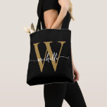Bolsa Tote Elegante Dourado Preto Feminino Personalizado Mono<br><div class="desc">Bolsa de mão com monograma inicial em preto e dourado, elegante e simples, personalizada com nome ou iniciais em letra manuscrita. Este design apresenta seu primeiro nome em uma linda tipografia de letra manuscrita com cauda ornamentada (ou caligrafia) com monograma inicial em dourado e branco sobre preto. Ótimo presente feminino...</div>