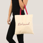 Bolsa Tote Fonte Bridesmaid Burgundy<br><div class="desc">Uma bela sacola de tote para uma bela dama de pontas,  esta design apresenta "Bridesmaid" escrita com uma adorável letra cursiva de burgundy.  Faça seu pedido hoje mesmo!</div>